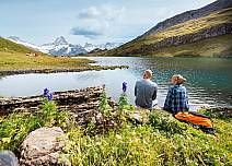 Pause for a moment at the lakeside and let your mind wander - surrounded by bright alpine flowers such as the aconite. With Scheckhorn in the distance.  (bei Klick vergrösserte Ansicht Bild)